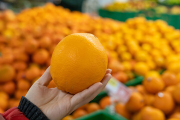 Pick orange, female hand pick up orange in supermarket.