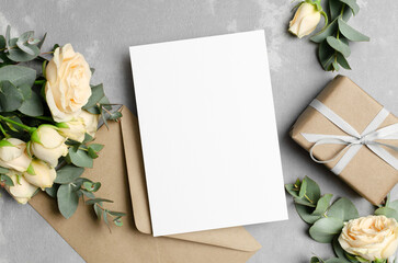 Invitation or greeting card mockup with fresh flowers, envelope and gift