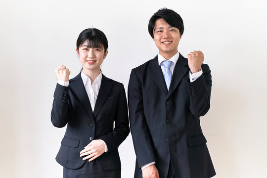 ガッツポーズをするスーツ姿の男女の学生