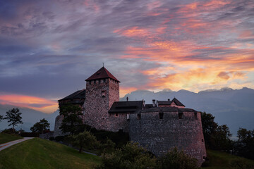Vaduz Castle, the official residence of the Prince of Liechtenstein, with Alps mountains in background on sunset.