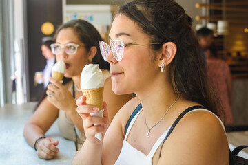 young woman enjoying an ice cream sitting inside a fast food restaurant