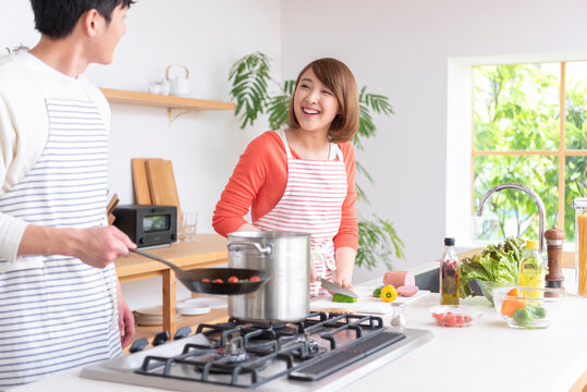 キッチンで料理する２０代夫婦