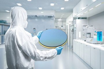 Worker or engineer wears medical protective suit or white coverall suit with silicon wafer