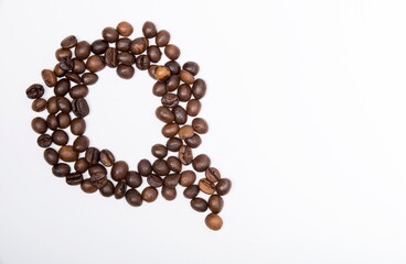 Q is a capital letter of the English alphabet made up of natural roasted coffee beans that lie on a white background.