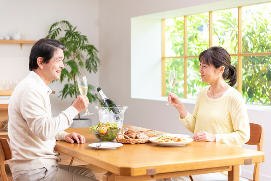 休日にシャンパンを飲み昼食する中高年夫婦