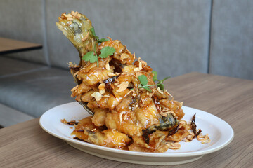 Thai style seafood, Deep Fried Seabass Fish with  Sweet-Sour Tamarind Sauce recipe on white plate. 