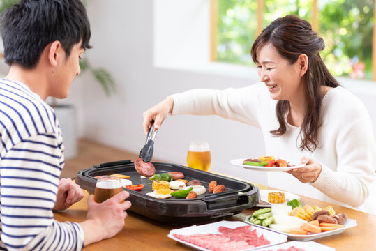 生ビールで焼肉を食べる３０代夫婦