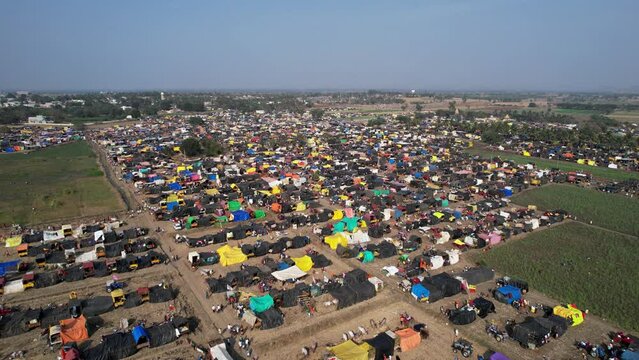 Aerial shot of a crowded county fair with colourful tents, shops, and devotees