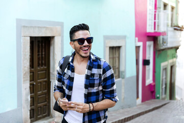 Mexican student in Guanajuato city, exploring a colorful village with a checked shirt. 