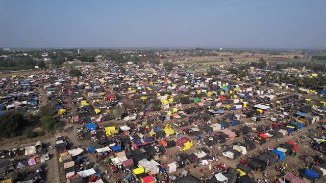 Aerial shot of a crowded county fair with colourful tents, shops, and devotees