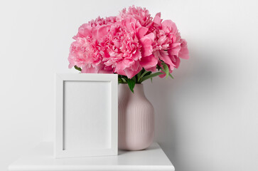Blank white photo frame mockup with big pink peony flowers bouquet