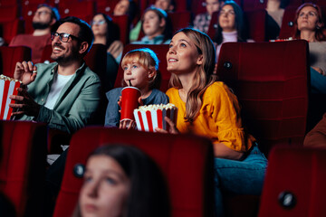 Family enjoying movie in theater.