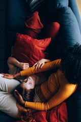 Fototapeta na wymiar lesbian couple cuddling on couch in the comfort of home