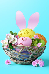 Multi colors Easter eggs in the basket with bunny ears and flowers on blue background. Pastel color Easter eggs.
