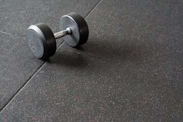Obraz na płótnie Canvas Black dumbbell. Weight Training Equipment. black dumbbells on the floor in dark concept fitness room with training equipments