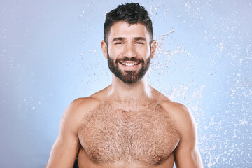 Water splash, portrait and man in studio skincare, wellness and cleaning on blue background. Face,...