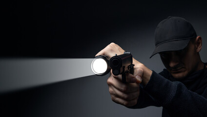 Professional security guard or policeman with flashlight and gun in dark room