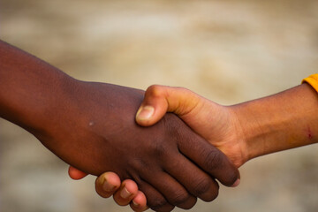 Here are two people together and they are shaking hands and the background is blurred