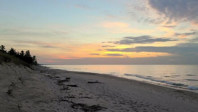 Beautiful sunset on tropical coast with sand beach and calm sea waves