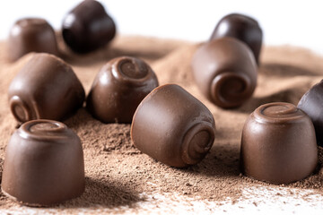 Chocolate bonbons and cocoa powder background. Close up
