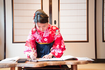 袴姿で筆を持っている女性