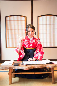 袴姿で筆を持っている女性