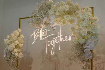 Better together text on photo-wall. Arch decorated flowers, greenery. Wedding reception. Celebration concept. Decorations in luxury ceremony in hall restaurant. Trendy decor for party in banquet area.