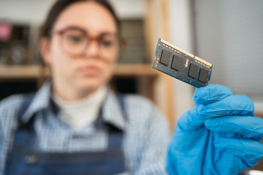 Laptop memory module in woman hands. Important computer component, close up. Electronic repair shop, technology development and construction.