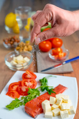 Male hand adding salt on salmon fillet. Healthy food. Keto diet. SDOF