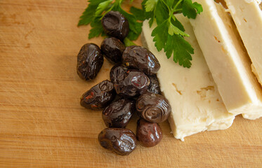 Feta cheese and black olives on wooden background.Turkish breakfast concept.