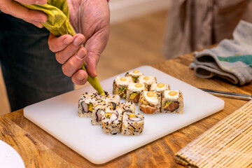 Chef finishes sushi with some wasabi