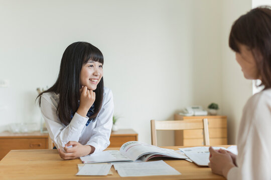 テーブルで資料を見ながら会話をする母娘