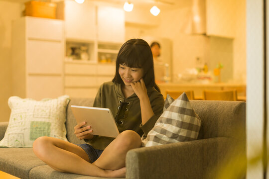 ソファーに座りタブレットPCを見る女の子