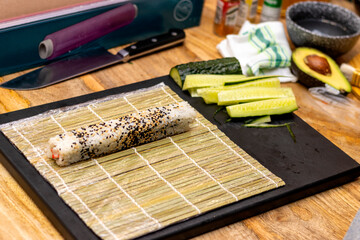 Sushi roll on the bamboo mat with ingredients