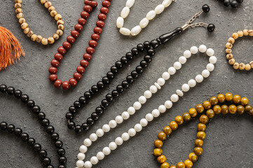 Several muslim prayer rosary on dark stone background, symbol of islam religion