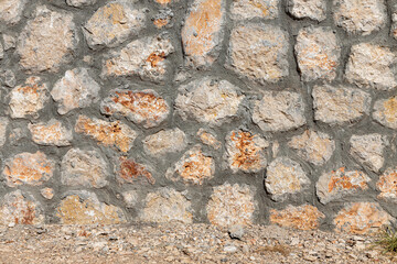 Beautiful texture of an old wall from orange stones with cracks