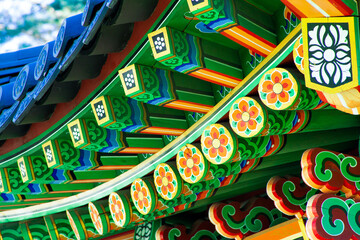 Pagoda. Close-up fragment of a bright wooden gazebo in the garden. Multicolored pattern. Traditional painted ornaments in Seoul, Republic of Korea. Bell of Friendship pagoda