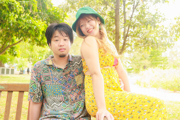 Naklejka premium 公園のベンチに仲良く座る日本人カップル
