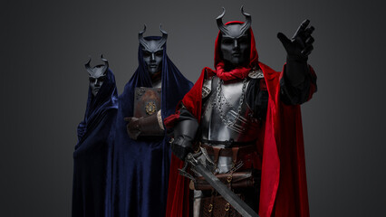 Portrait of two members of esoteric cult and their leader holding sword.