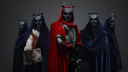 Portrait of four followers and their leader of dark cult dressed in dark robes.