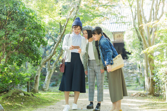 スマートフォンを覗く3人の女性