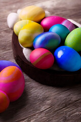Obraz na płótnie Canvas Handmade painted colorful easter eggs decoration on wood table top view with empty space made with generative ai