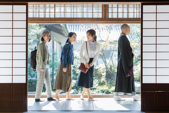 寺院を案内する住職と3人の女性