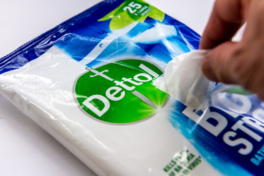 London. UK-02.12.2023. A person taking out a sheet of Dettol antibacterial wipe isolated in a white background.