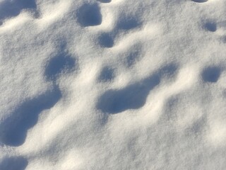Old footprints on white snow - background texture