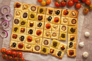 Puff pastry mini pies with cherry tomatoes, mushrooms, olives , feta cheese and onion. - obrazy, fototapety, plakaty