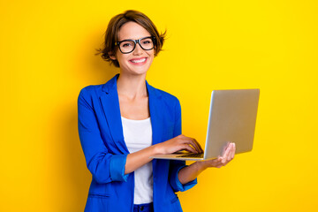 Photo of confident ukrainian it development junior programmer coder hold new apple laptop advert enjoy services isolated on yellow color background