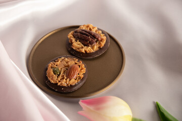 金色のトレーに載せたチョコフロランタン ピンクの背景とチューリップ