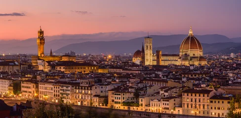 Papier Peint photo Florence The illuminated Florence cityscape with the Palazzo Vecchio and the Florence Cathedral in an orange and purple twilight.