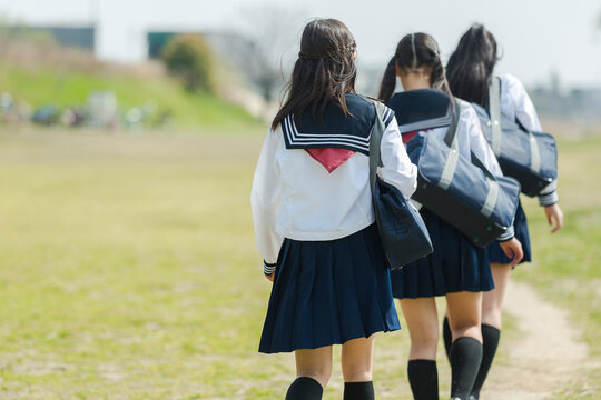 １列に並んで歩く女子校生